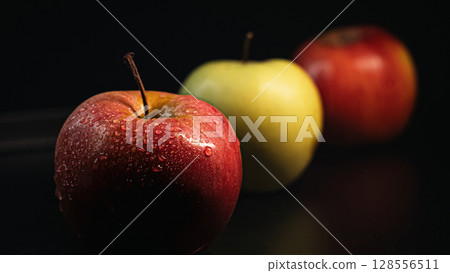 Three Apples in a Row on Black Background - Minimalist Fruit Composition 128556511