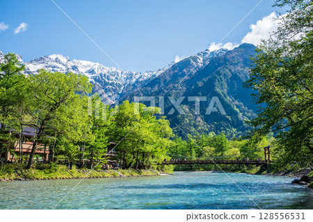 A spectacular view of Kamikochi: Kappa Bridge and the Hotaka mountain range in the season of fresh greenery 128556531