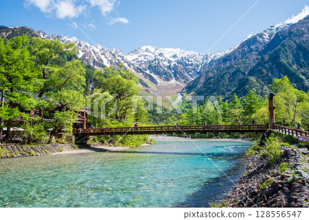 A spectacular view of Kamikochi: Kappa Bridge and the Hotaka mountain range in the season of fresh greenery 128556547