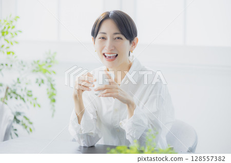在客廳裡喝咖啡的中年女人 128557382