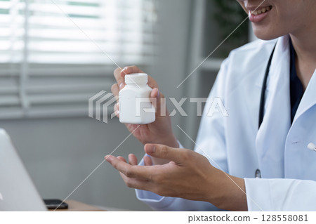 Medical Professional Holding Prescription Bottle in Modern Healthcare Setting 128558081