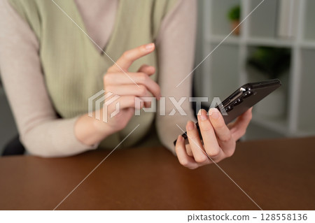 Business Professional Using Mobile Phone for Work in Modern Office Setting 128558136