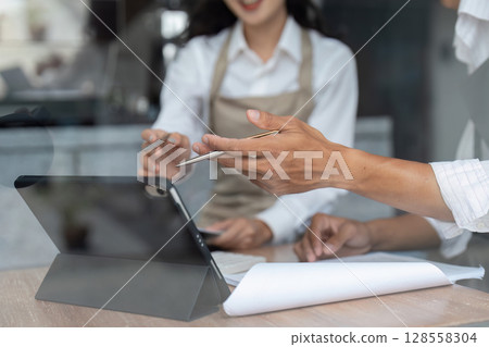 Business Meeting with Digital Tablet and Documents in Modern Office Setting 128558304