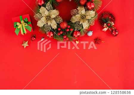 Festive Christmas Wreath and Decorations on Red Background with Gift Box and Ornaments 128558636