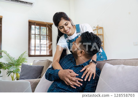 Happy Couple Relaxing at Home on a Comfortable Sofa in a Bright Living Room with Natural Light 128558703