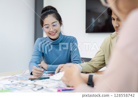Creative Team Collaborating on UX UI Design Project in Modern Office Environment Creative Team Collaborating on UX UI Design Project in Modern Office Environment 128558742