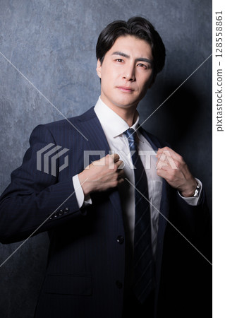 A businessman in a suit adjusting his collar and getting ready A businessman in a suit adjusting his collar and getting ready 128558861