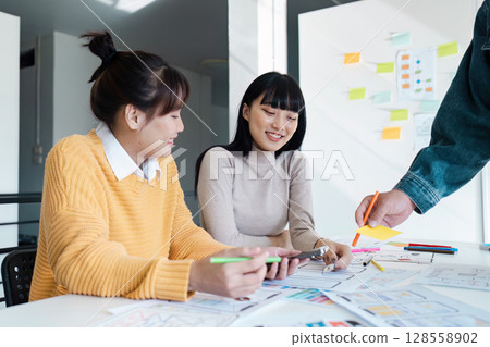 Creative Team Collaborating on UX UI Design Project in Modern Office Setting Creative Team Collaborating on UX UI Design Project in Modern Office Setting 128558902