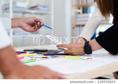 Creative Team Collaborating on UX UI Design Project with Wireframes and Prototypes 128558924