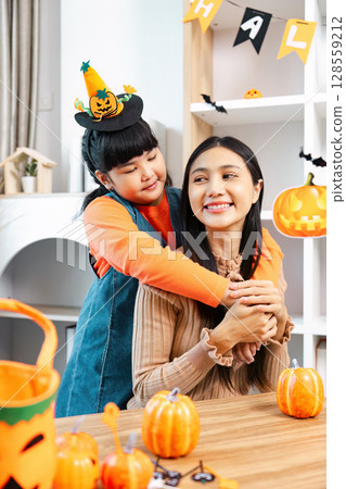 Mother and Daughter Celebrating Halloween with Pumpkins and Decorations at Home Mother and Daughter Celebrating Halloween with Pumpkins and Decorations at Home 128559212