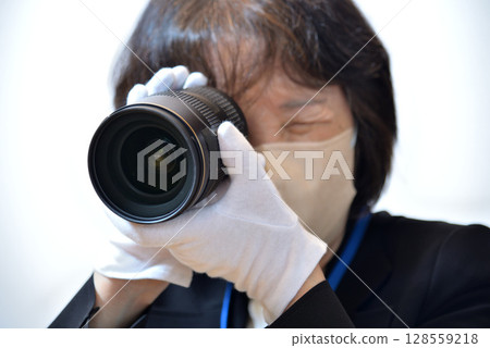 Image of an appraiser evaluating a camera lens Image of an appraiser evaluating a camera lens 128559218