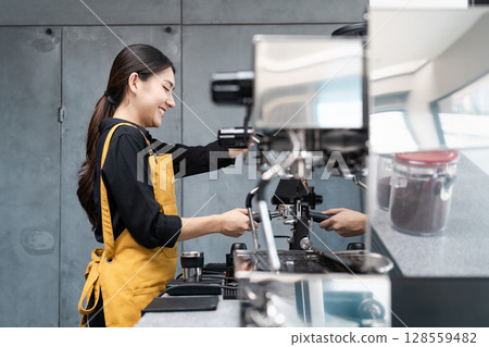 Barista Preparing Coffee Using Espresso Machine in Modern Cafe with Industrial Design Barista Preparing Coffee Using Espresso Machine in Modern Cafe with Industrial Design 128559482