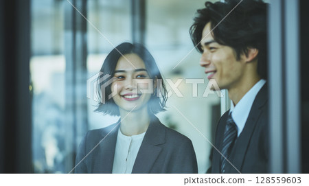 Young employees smiling and chatting in the office 128559603