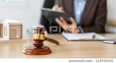 Gavel and Lawyer Taking Notes in Office 128559702