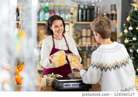 Female employee sells chips to adolescence boy on Christmas Eve Female employee sells chips to adolescence boy on Christmas Eve 128560127
