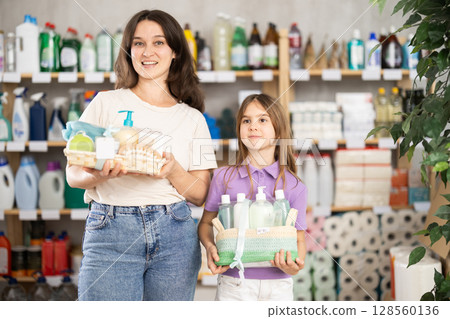 Mother and daughter choose gifts for relatives in home goods store - shampoo, liquid soap and bathroom accessories Mother and daughter choose gifts for relatives in home goods store - shampoo, liquid soap and bathroom accessories 128560136