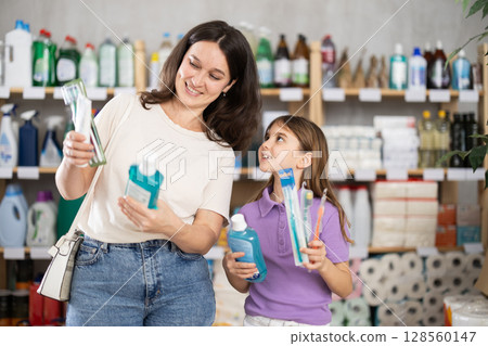 Woman with daughter choosing dental care products 128560147