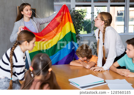 Female teacher explaining lgbt theme to children during lesson in class Female teacher explaining lgbt theme to children during lesson in class 128560185