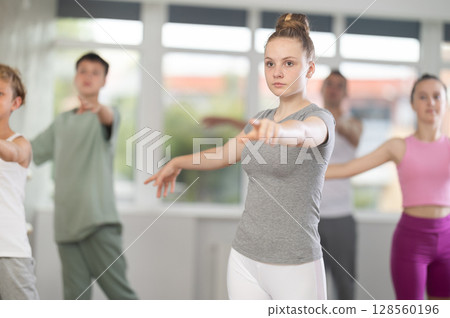 Girls and boys are learning various dance and ballet movements in studio Girls and boys are learning various dance and ballet movements in studio 128560196