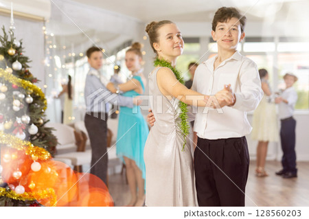 Couples dancing - teenagers in festive clothes dance the Viennese waltz near Christmas tree 128560203