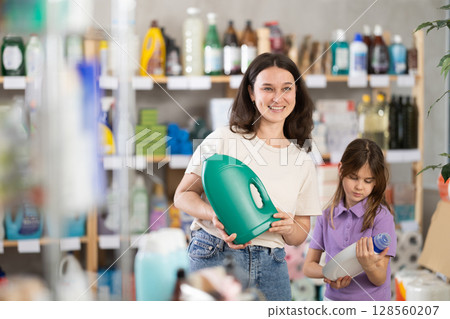 woman with a child chooses a detergent 128560207