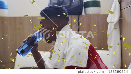 Image of confetti falling over football player drinking water in changing rooms Image of confetti falling over football player drinking water in changing rooms 128560224