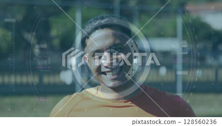 Scope scanning over digital interface with data processing against male soccer player smiling Scope scanning over digital interface with data processing against male soccer player smiling 128560236