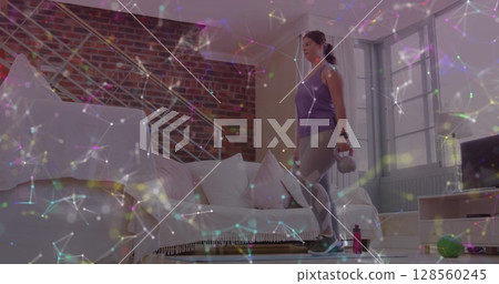 Image of network of connections over woman lifting kettlebells exercising at home Image of network of connections over woman lifting kettlebells exercising at home 128560245