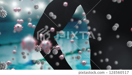 Covid-19 cells floating against silhouette of male swimmer against swimming pool 128560517