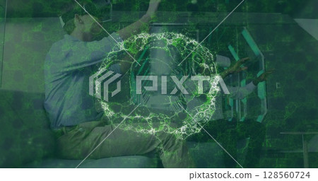 Image of brain scan and medical data processing on interface, over man and woman in vr headsets 128560724