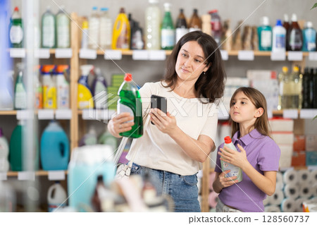 Woman and girl clients, by scanning QR code, gain access to information about dishwashing detergent Woman and girl clients, by scanning QR code, gain access to information about dishwashing detergent 128560737