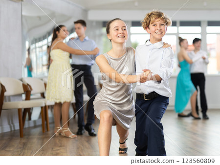 Teen boy and girl are dancing contemporary modern discofox in couple during lesson at studio 128560809