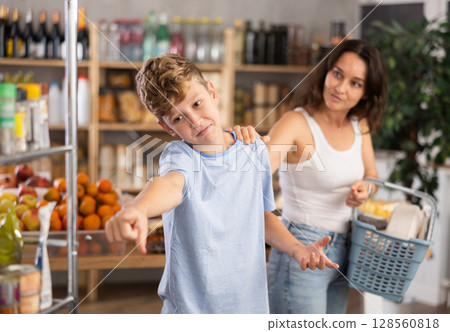 Disgruntled boy asks mom to buy at grocery store 128560818