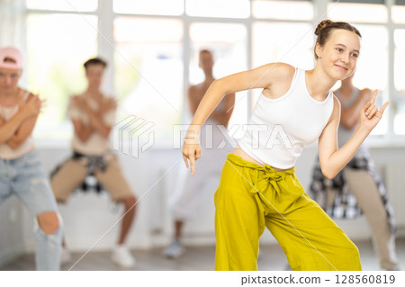 Group of girls an boys perform choreographic exercises and teaches energetic breakdancing waacking together Group of girls an boys perform choreographic exercises and teaches energetic breakdancing waacking together 128560819