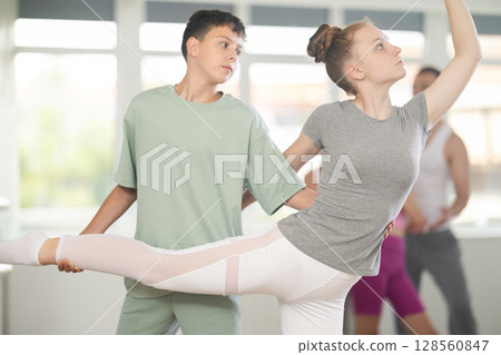 Boy and girl in pair train to perform ballet dance during rehearsal in studio Boy and girl in pair train to perform ballet dance during rehearsal in studio 128560847