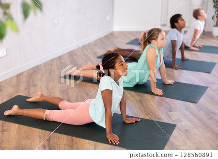 Preteen Children practicing yoga in Urdhva Mukha Shvanasana in gym 128560891