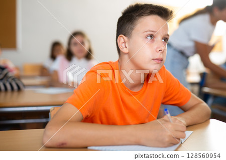 School boy sitting at the desk in classroom at lesson in primary school School boy sitting at the desk in classroom at lesson in primary school 128560954
