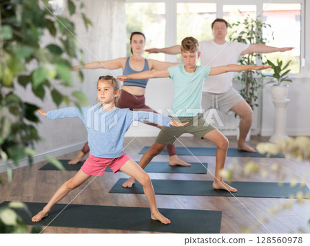 Family with children practicing various yoga positions during training 128560978