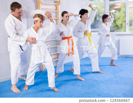 Group of children train karate techniques Group of children train karate techniques 128560987
