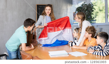 Teacher showing Holland flag to group of schoolchildren 128561003