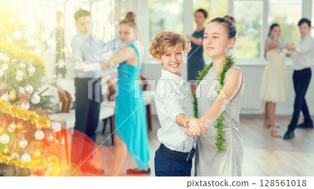 Couples dancing - teenagers in festive clothes dance the Viennese waltz near Christmas tree 128561018