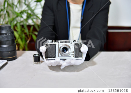 Image of an appraiser evaluating a camera 128561058