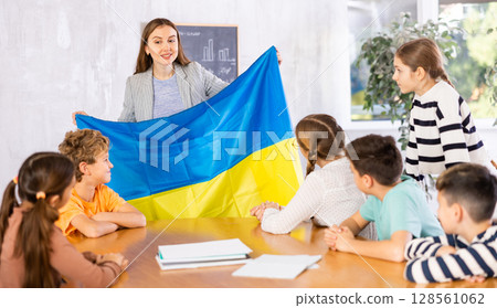 Teacher showing Ukraine flag to group of schoolchildren 128561062