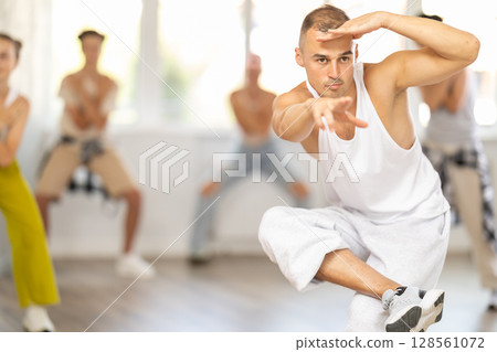 Male trainer dancing hip hop with group of teenagers 128561072