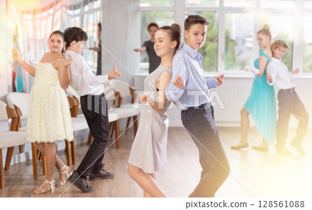 Teenagers standing back-to-back in pairs and snapping fingers during jazz-style routine Teenagers standing back-to-back in pairs and snapping fingers during jazz-style routine 128561088