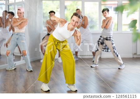 Group of sporty teenagers practicing hip hop dance in training hall during dancing classes 128561115