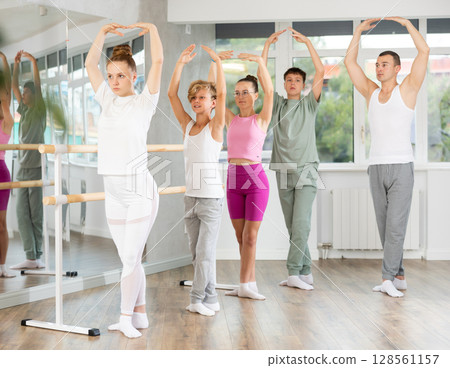 Teenage boys and girls practicing fifth position of ballet in dancehall 128561157