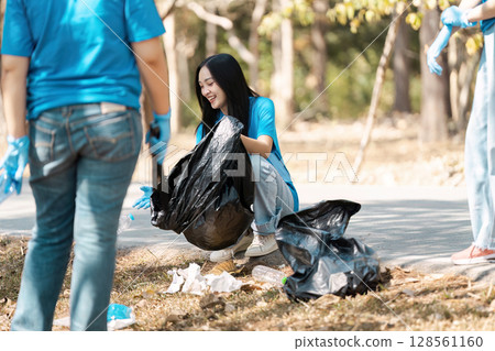 Young Volunteers Cleaning Up Park Litter on a Sunny Day, Engaging in Community Service and Environmental Conservation Young Volunteers Cleaning Up Park Litter on a Sunny Day, Engaging in Community Service and Environmental Conservation 128561160