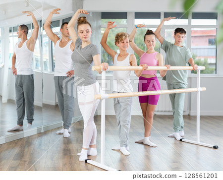 Girls and boys in ballet class perform third position under male teacher guidance. Girls and boys in ballet class perform third position under male teacher guidance. 128561201