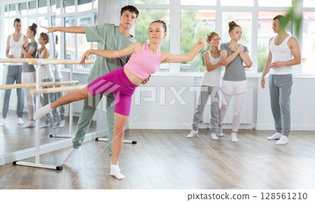 Boy and girl in pair train to perform ballet dance during rehearsal in studio Boy and girl in pair train to perform ballet dance during rehearsal in studio 128561210